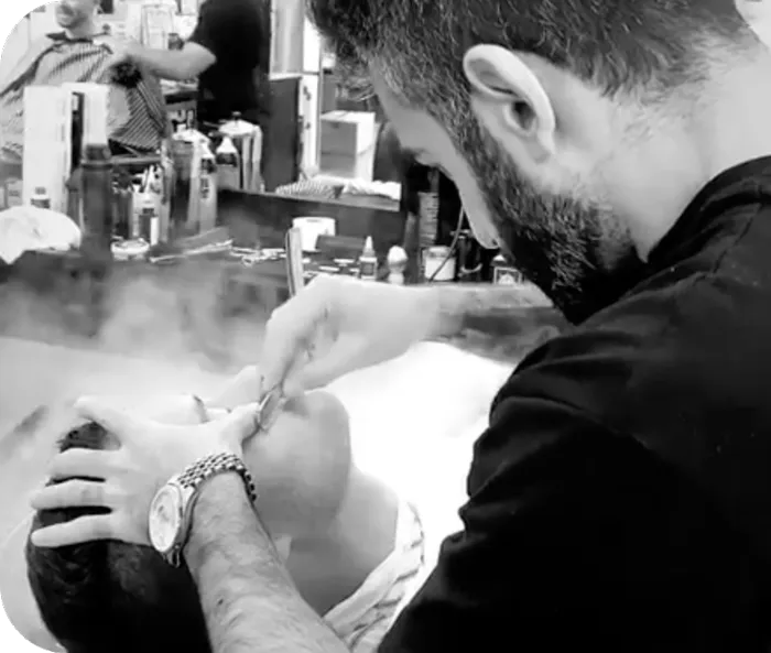 A person getting a straight shave during a groomsman party at modern man barbershop located in barkers at the crossing Christchurch cbd.